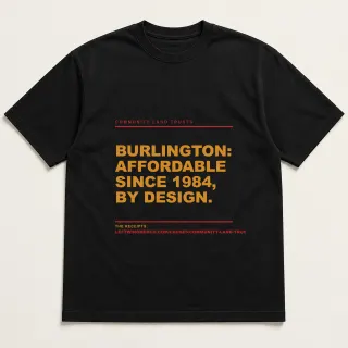 Front of a black tee reading "Burlington: affordable since 1984, by design." with the Community Land Trusts page address printed under it