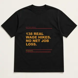 Front of a black tee reading "138 real wage hikes. No net job loss." with the Minimum Wage page address printed under it