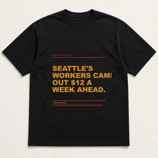 Front of a black tee reading "Seattle's workers came out $12 a week ahead." with the Minimum Wage page address printed under it