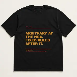 Front of a black tee reading "Arbitrary at the NRA. Fixed rules after it." with the New Deal page address printed under it