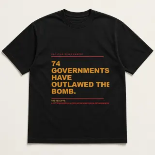 Front of a black tee reading "74 governments have outlawed the bomb." with the Nuclear Disarmament page address printed under it